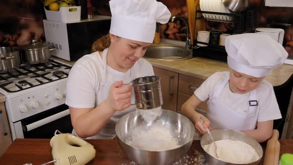 A Mother Teaches Her Son How to Cook Cookies She Holds a Flour Sieve