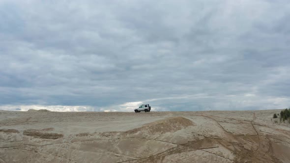 Aerial View of a Car Driving on Sand