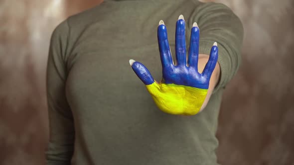 Hand of a Girl With the Flag of Ukraine Asks to Stop the War