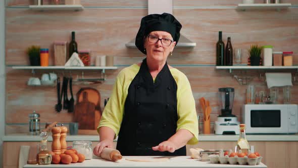 Old Woman Rolling the Dough at Video Camera