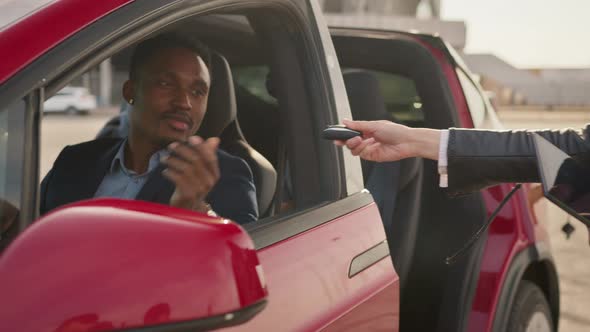 Female Auto Seller Giving Keys to Male Customer Form His New Electric Car