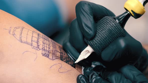 Male Tattoo Artist Tattooing a Client