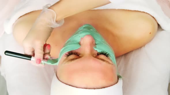 Beautician cosmetologist applying face alginate beauty mask. professional cosmetic procedure