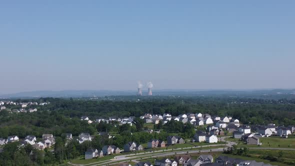 small town aerial view with nuclear power plant towers in background