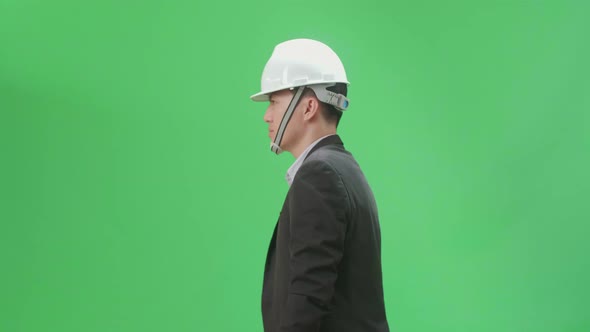 Side View Of Asian Chief Engineer In The Hard Hat Walks On Green Screen Chroma Key