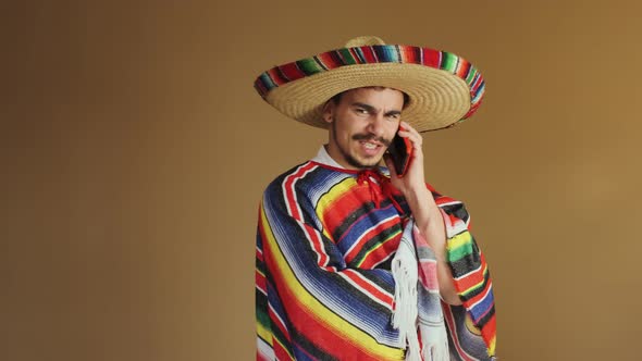 Young Mexican In Multicolored Poncho And Hat