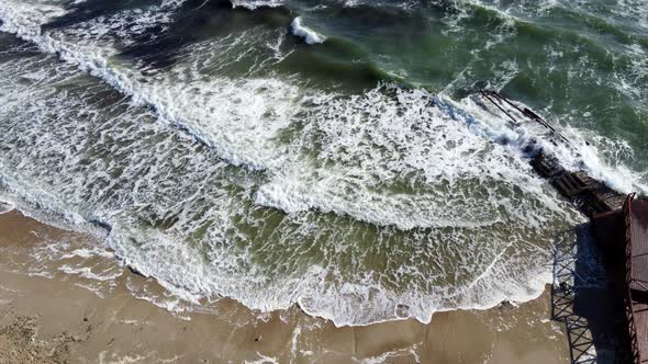 Aerial Drone View Flight Over Waves That Roll Onto the Sandy Shore