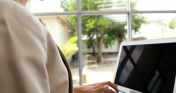 Businesswoman using laptop in office 4k