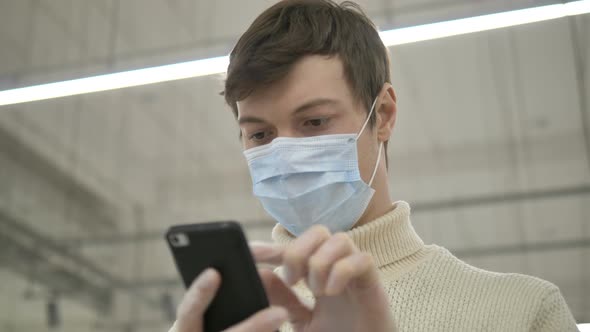 Man Protective Mask Rubber Gloves Uses Smartphone Communicate Work in Supermarket