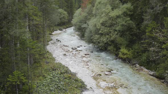 Aerial view of Fast Moving River with Rapids Surrounded by Forest