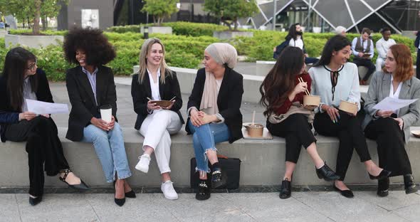 Young multiracial women doing lunch break together outside of office