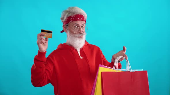 Grayhaired Hipster Man in a Red Hoodie Makes Successful Purchases Online Using a Credit Card a