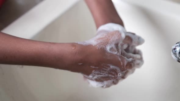 Young Man Washing Hands with Soap Warm Water