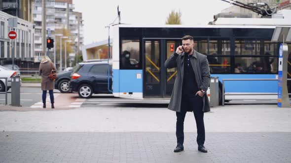 Professional businessman using mobile phone. Young businessman talking on smart phone on street