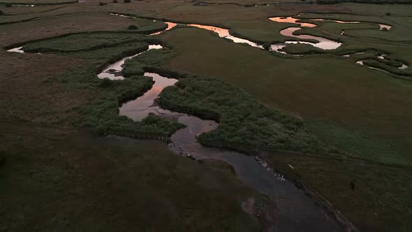 Aerial view looking down at river winding through pastures