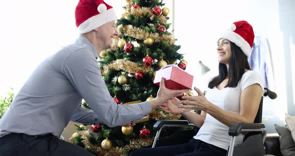 Young Man Gives Beloved Woman Sitting in Wheelchair Christmas Present Slow Motion  Movie