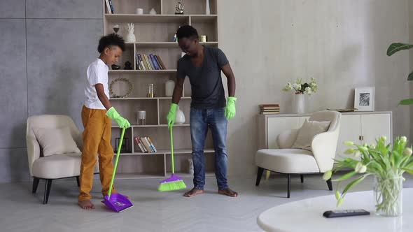Young Dad and Son Cleaning Room and Having Fun in Apartment During Quarantine Spbi