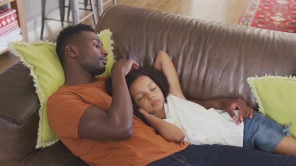 African american father and daughter sleeping in sofa