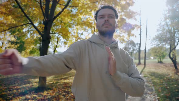 Handsome Man Exercising and Stretching Before Morning Run at the Park in Autumn