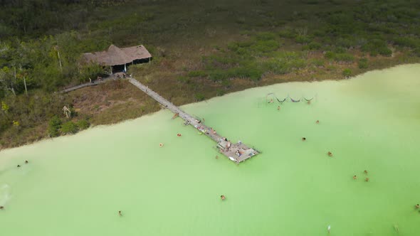 Aerial Descending Footage of People Relaxing in Green Water
