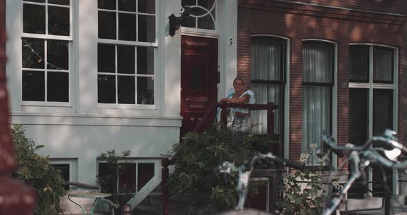 Woman sits and smiles on doorstep