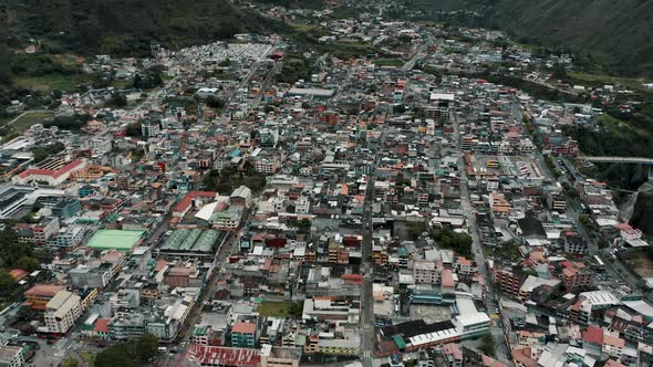 Baños de Agua Santa Town Nestled At The Base Of Tungurahua Volcano In Ecuador. Aerial Drone Shot