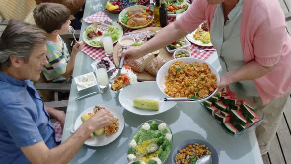 Family eating outside together in summer