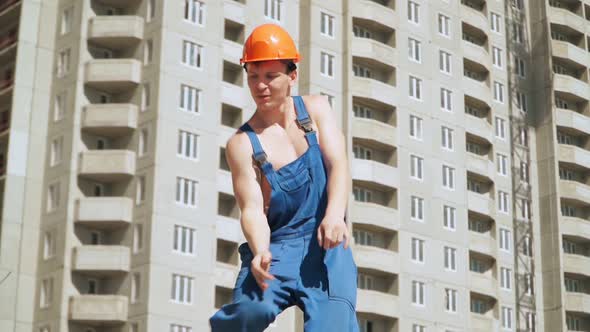 Happy Caucasian Man Builder in Hard Hat Dancing. Worker Funny Moves Background Construction Site