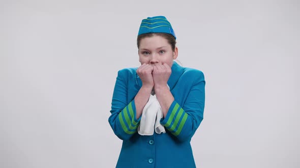 Shocked Scared Caucasian Girl in Stewardess Uniform Posing at White Background