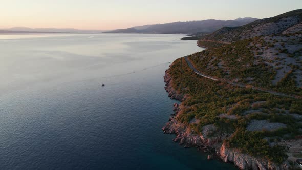 Aerial View of the Rocky Coast of Croatia with a Curve Road at Sunset Time