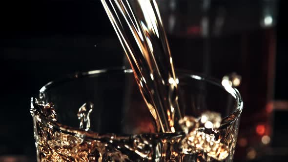 Cognac with Splashes is Poured Into a Glass