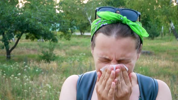 Woman with pollen allergy symptom smelling air with nose Sick girl sneezing blowing in handkerchief