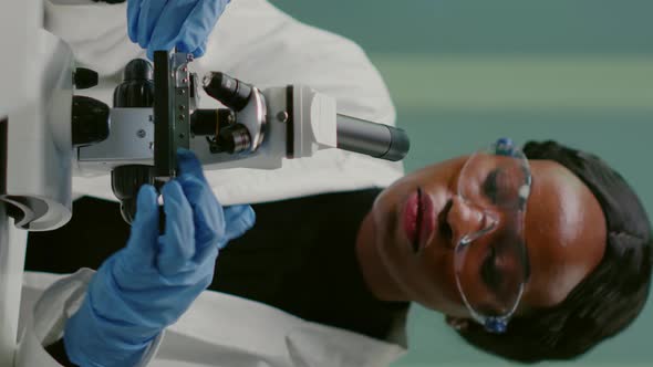 Vertical Video Portrait of Pharmaceutical Woman Putting Slide Under Microscope