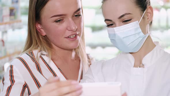 Professional Pharmacist Helping Her Female Customer Choosing Products at the Drugstore