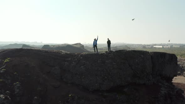 Aerial View of Icelandic Landscape with Slow Camera Rotation Around Two Climber Standing on a Cliff