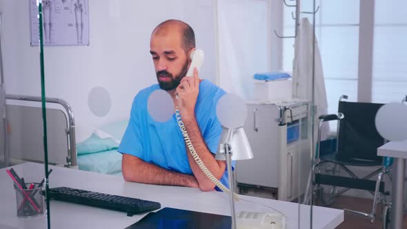 Assistant Talking at Phone Checking Appointment Sitting Behind a Glass Wall