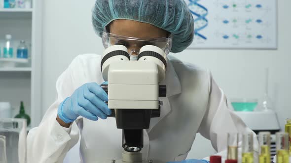 Female Scientist Zooming on Microscope Specialist Doing Blood Research