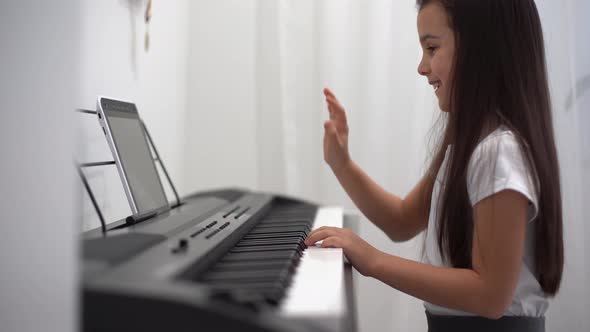 A Little Girl Learns to Play the Piano From Video Lessons