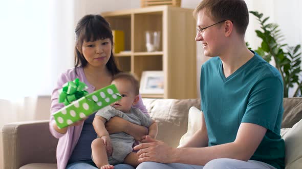 Mother with Baby Giving Birthday Present To Father 