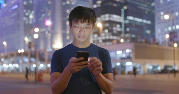 Man use of mobile phone in city at night