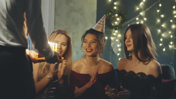 Young Woman Blowing Out Fire on Candles and Making Wish at Party or Celebration. Close-up Portrait