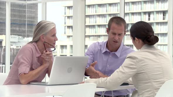 Three Businesspeople in Office Meeting