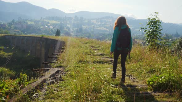 Hiker Girl Crossing The Old Stone Bridge 