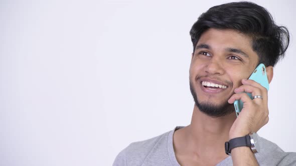 Young Happy Bearded Indian Man Thinking While Talking on the Phone