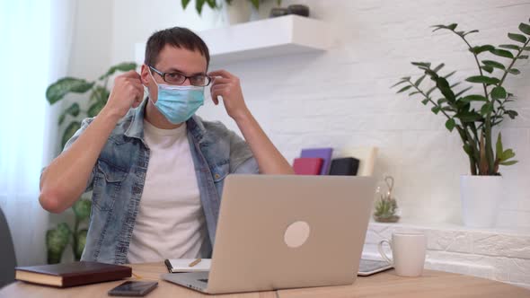 Portrait of Young Businessman Takes Off Face Mask at Workplace