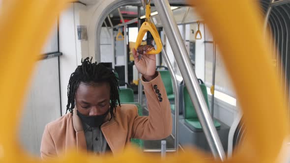 African American Guy in Cadual Clothes Use Phone in Public Transport