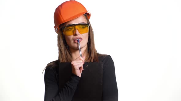 Young woman construction worker in hard hat on a white background.