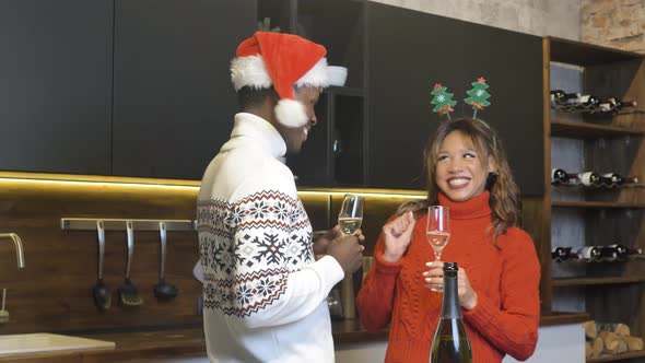 Cute AfricanAmerican Couple Drinking Champagne From Glasses and Chatting Celebrating the New Year