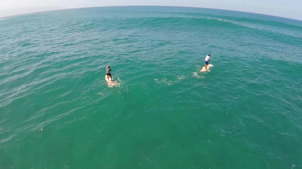 Aerial view of a man paddling while sup stand-up paddleboard surfing in Hawaii.