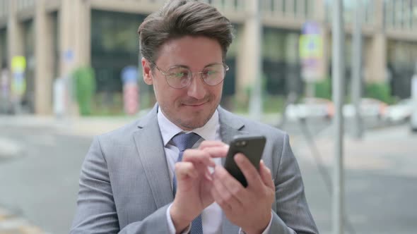 Businessman Browsing Internet on Smartphone, Outdoor